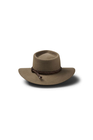 The Akubra The Brumby is a wide-brimmed brown hat with a rounded crown and braided leather band, ideal for Australian outback or bush festivals, shown on a white background with a subtle shadow beneath.
