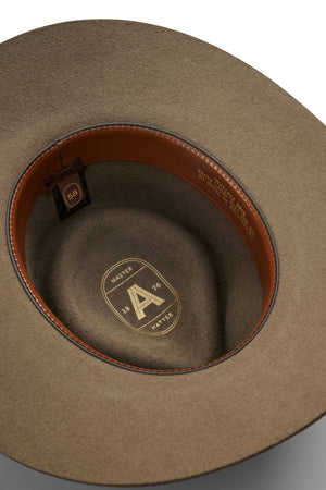 Close-up of the inside of an Akubra The Brumby felt hat with a tan leather sweatband and oval logo reading "MASTER A 1876 HATTER" plus size "58"—a classic choice for bush festival adventures in the Australian outback.