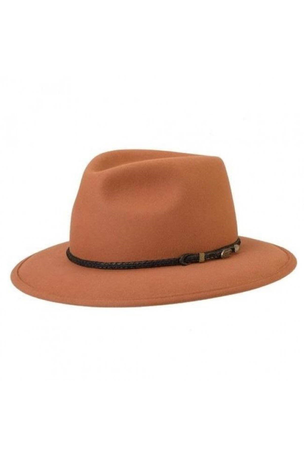 The Akubra Traveller is a light brown felt fedora hat with a wide brim and a black braided band, featuring a small metallic accent on the side. It has a classic, slightly indented crown and boasts a simple, elegant design.