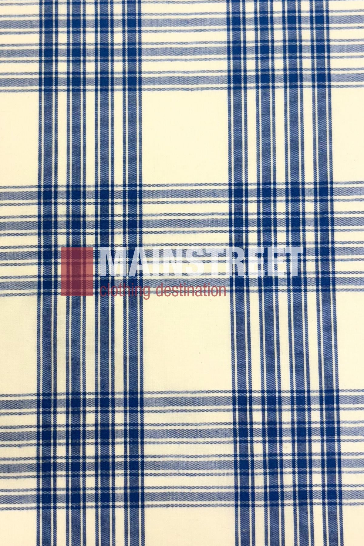 The Bisley Western Shirt is a white polyester-cotton blend with a blue plaid pattern of intersecting lines. "MAIN STREET" and "clothing destination" are printed in white and red, capturing a classic Countryman Shirt feel.