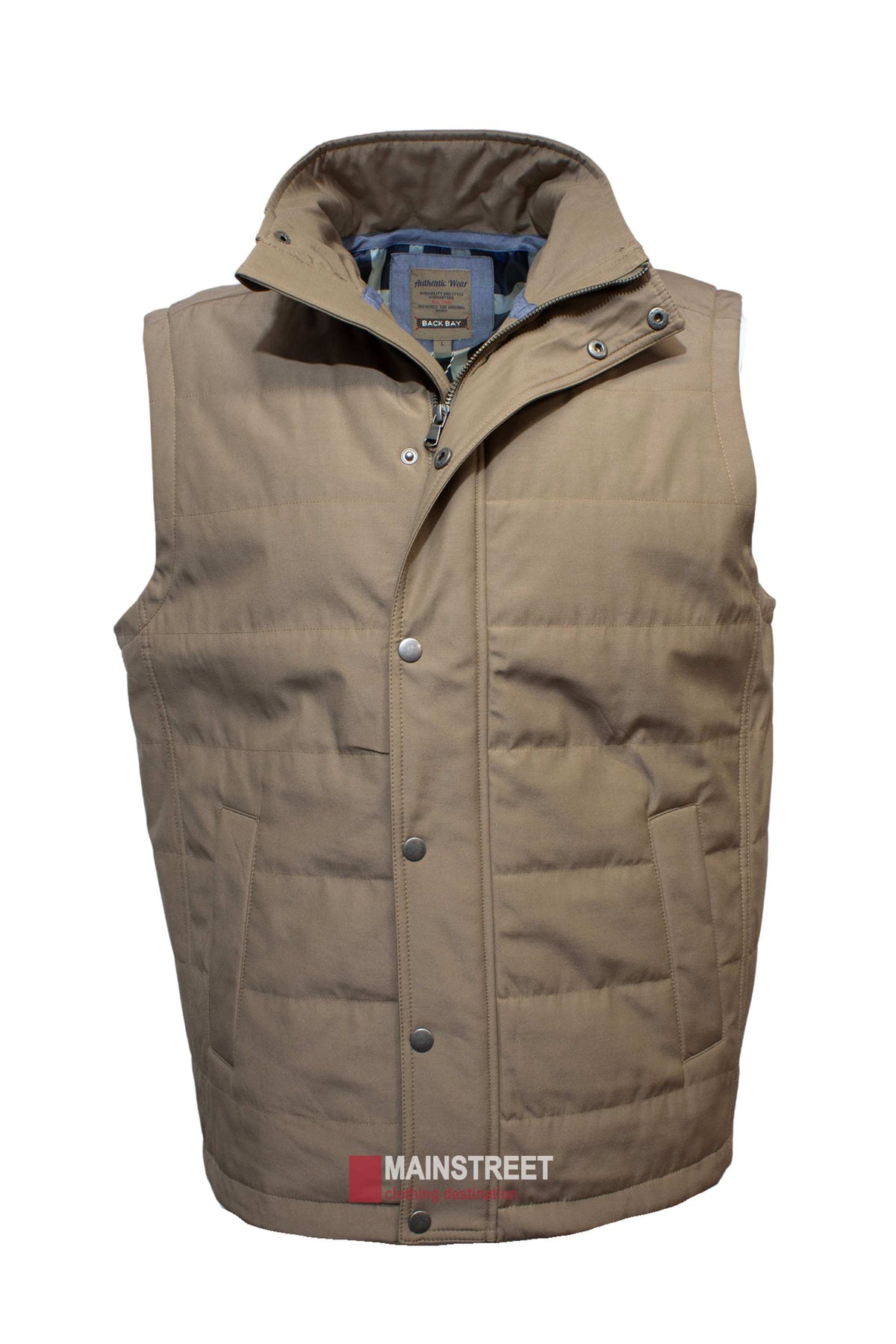 The Back Bay Lifestyle Vest is a tan, sleeveless Cotton/Polyester vest with quilted detailing, stand-up collar, snap buttons, zipper closure, two front pockets, interior neck label, and "MAINSTREET" printed near the hem.