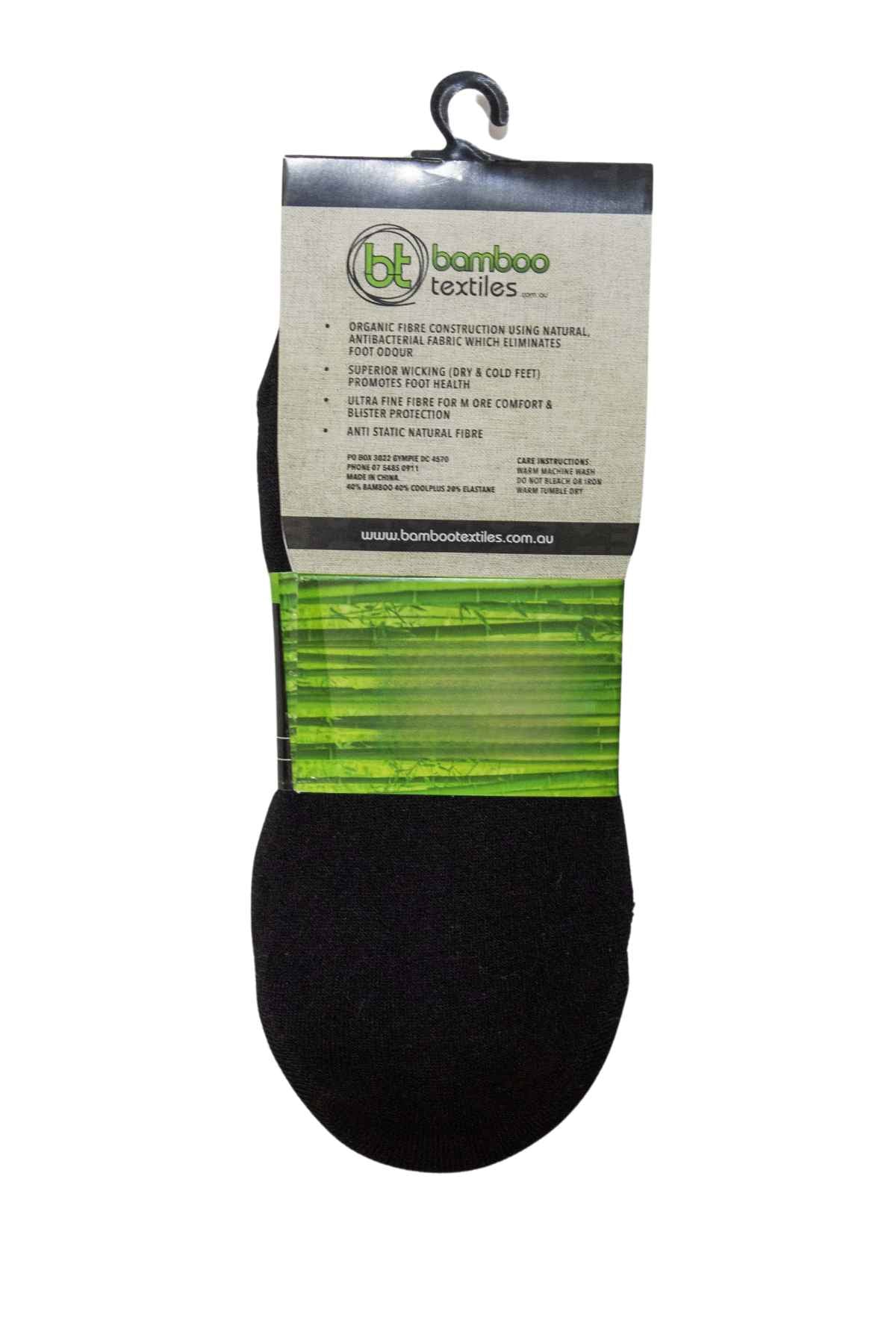 A pair of Bamboo Invisi socks in black is displayed on a hook, with packaging that incorporates a green section detailing their benefits, including moisture wicking, comfort, and anti-static properties. Made from antibacterial fabric for lasting freshness, the label also includes the website URL at the bottom.