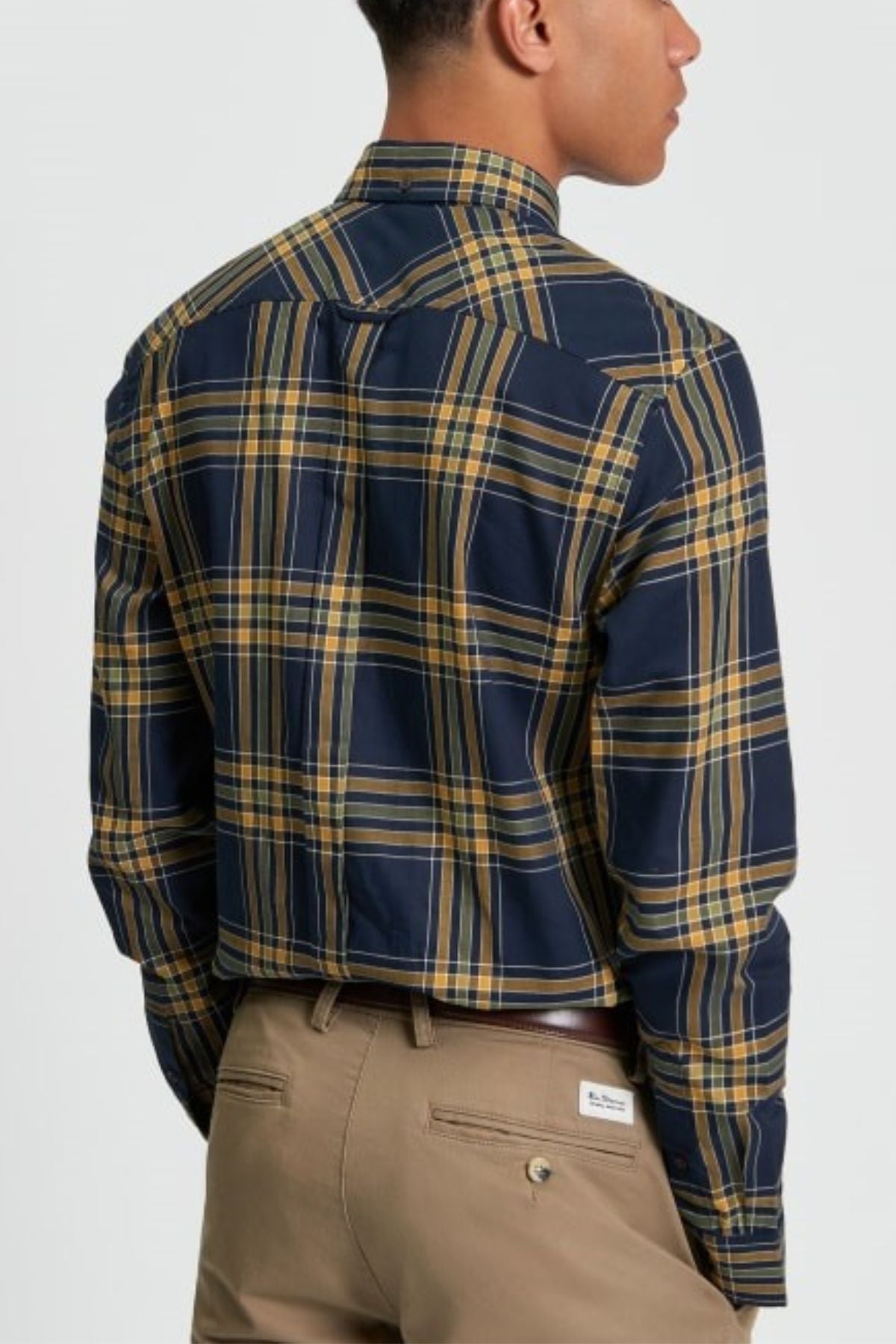 Back view of a man wearing the Ben Sherman Grid Check Shirt in navy and yellow plaid, paired with khaki chinos and a brown belt.
