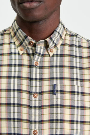 A person wearing the Ben Sherman Multicolour Oxford Check Shirt with a yellow, red, and blue plaid pattern, front pocket featuring a small dark tag, and brown buttons. Only the lower half of their face and upper torso are visible.