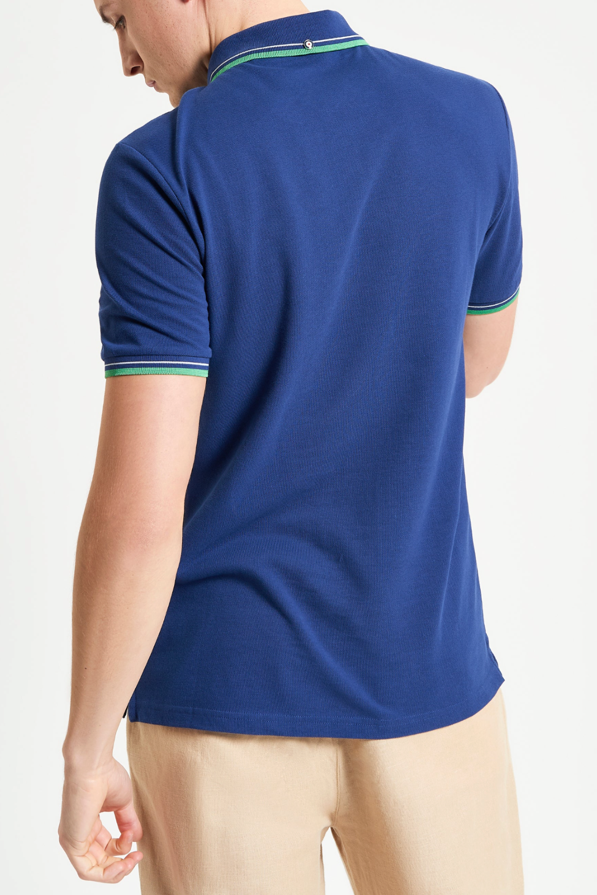A person is shown from the back wearing a blue Ben Sherman Signature Pique Polo with green and white trim on the cuffs and collar, paired with beige pants, set against a plain white background.