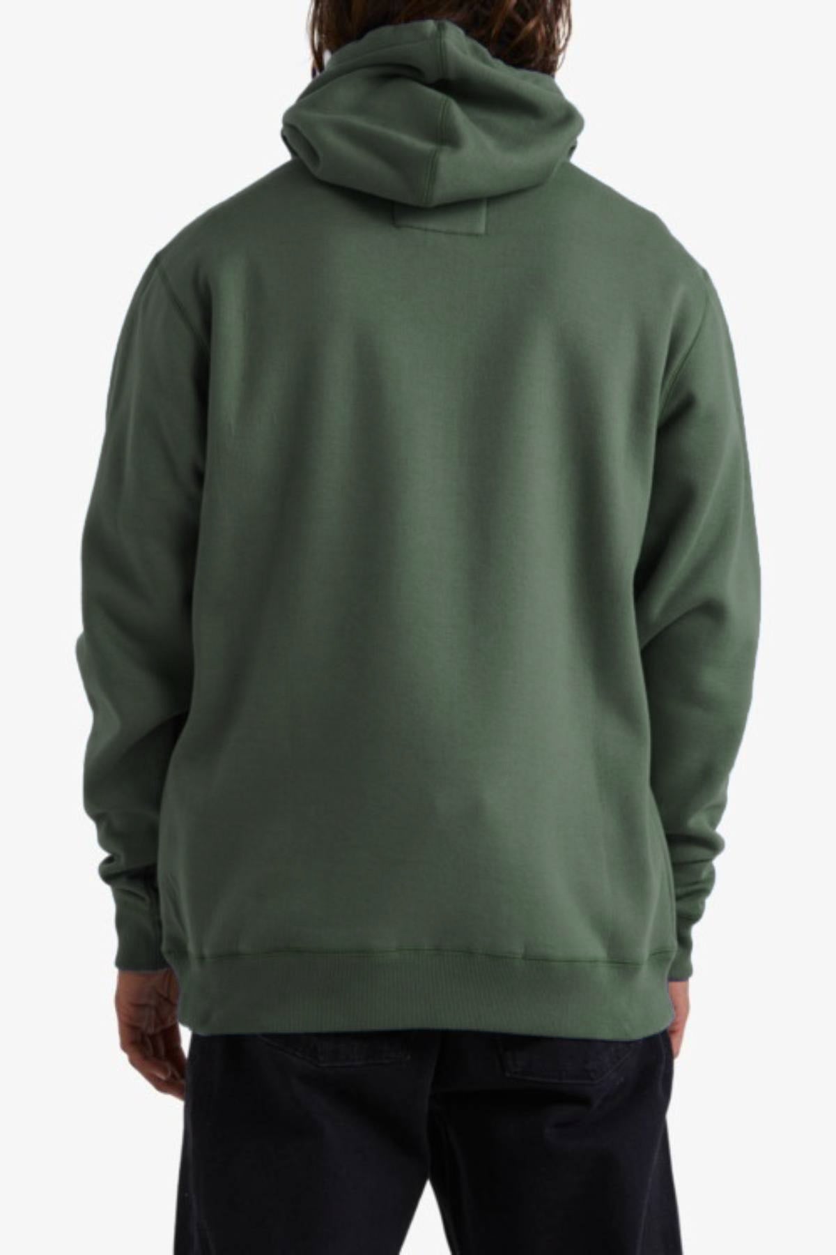 A person is seen from behind wearing a forest green Billabong Shoreline Pullover hoodie with long sleeves, relaxed fit, and cozy fleece lining, paired with dark pants against a plain white background.