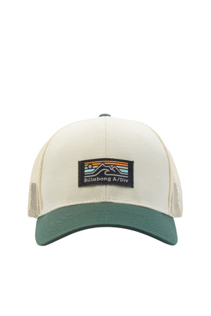 The Billabong Walled A/DIV Trucker is a beige and green hat made of recycled polyester with a mesh back. It features a patch with an abstract mountain design and "Billabong A/Div" text, plus an adjustable snapback closure for comfort.