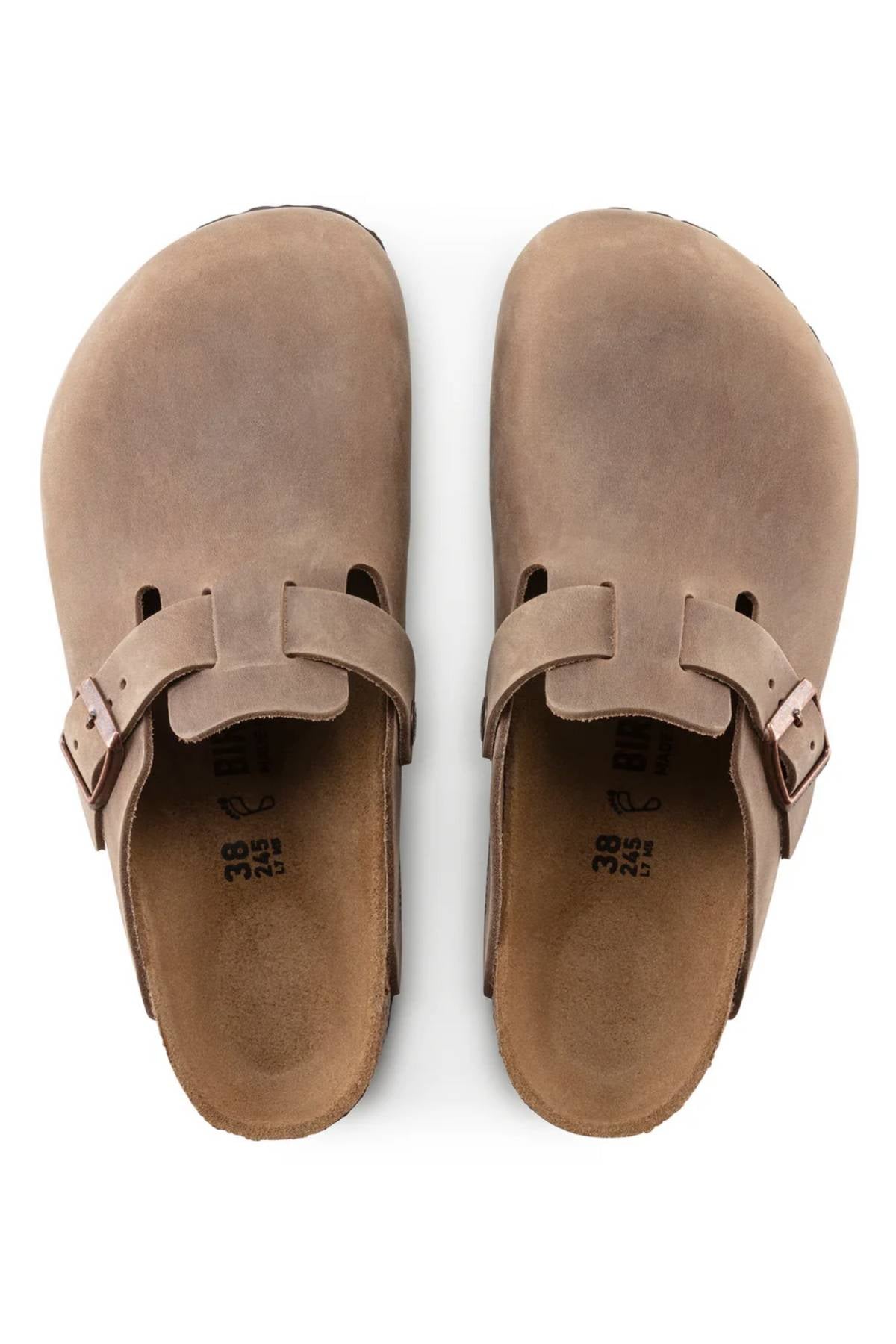 A pair of Birkenstock Boston brown suede closed-toe slip-on clogs with adjustable side buckles and an anatomically shaped footbed, viewed from above.