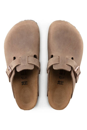 A pair of Birkenstock Boston brown suede closed-toe slip-on clogs with adjustable side buckles and an anatomically shaped footbed, viewed from above.
