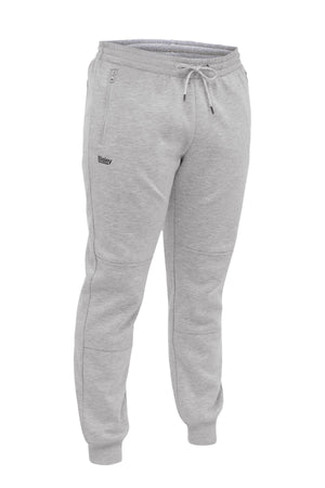 The Bisley Work Fleece Trackpant features light gray fleece, an elastic waistband with drawstring, cuffed ankles, side zipper pockets, and a small "Bailey" logo on the left thigh—blending comfort with workwear style.