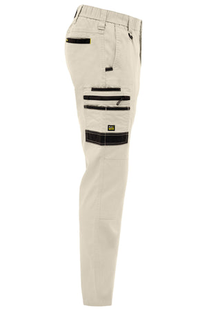 Side view of Bisley Flex & Move Stretch Canvas Elastic Waist Cargo Pant in beige, featuring multiple black zippered pockets, an elastic waistband, and a small rectangular logo on the thigh pocket.