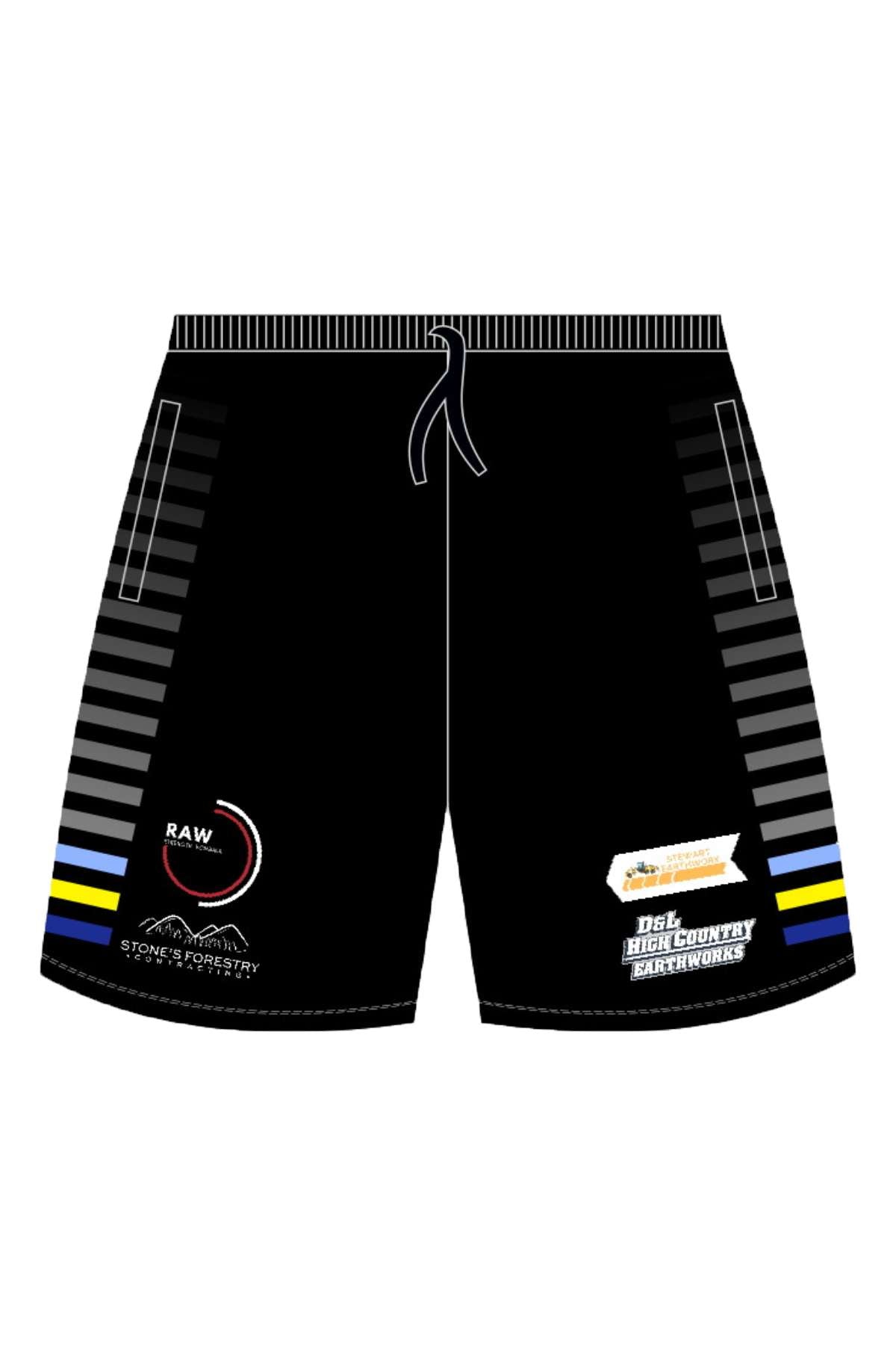 Black Bombala Blue Heelers training shorts feature gray side stripes, zip pockets, logos for "Raw," a mountain graphic, "Stone Property Services," and "Del High Country Fireworks" with a firecracker image. They have thin blue and yellow bands at the bottom of the stripes.