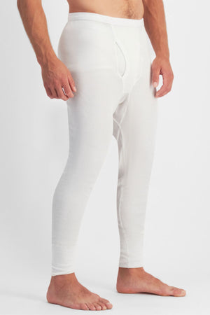 A man stands barefoot wearing Bonds Aircel Thermal Long Johns, shown from the shoulders down in side view, featuring a ribbed elastic waistband, visible front fly, and a comfortable ribbed texture.
