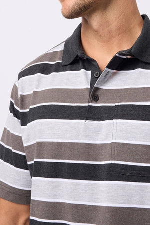 A man wears the Breakaway Coleman Kinnersly Polo, a men's polo shirt boasting short sleeves and bold horizontal black, gray, and white stripes on a light background, made from a comfortable cotton-polyester blend.