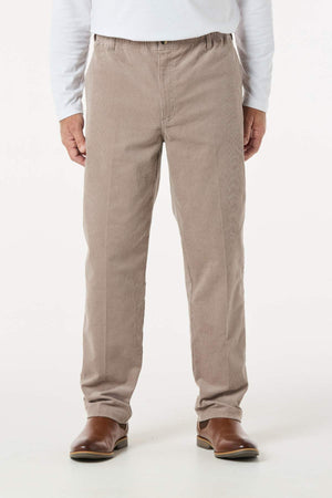 A person, shown from the shoulders down against a plain white background, wears light brown Breakaway Cordeaux Pant with an elasticised waist, paired with a white long-sleeve shirt and brown boots.