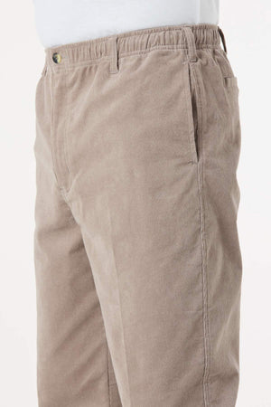 A close-up side view showing a person wearing the Breakaway Cordeaux Pant in light brown with an elasticised waist, paired with a white shirt tucked in.