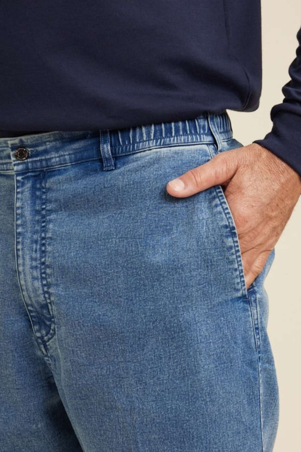 Close-up of a person wearing Breakaway Intense Denim Jean with a straight leg cut and navy long-sleeve shirt, their right hand partially in the front pocket.