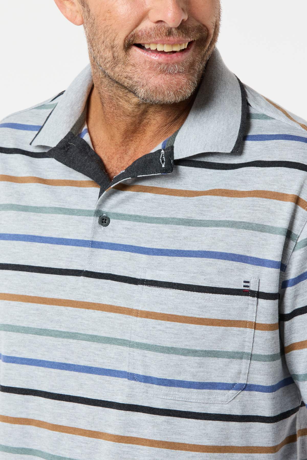 A man wearing the Breakaway Lendel Kinnersly Polo with blue, green, black, and brown stripes smiles while looking to the side. This polo features a chest pocket, rib knit cuff sleeves, and a buttoned neckline.