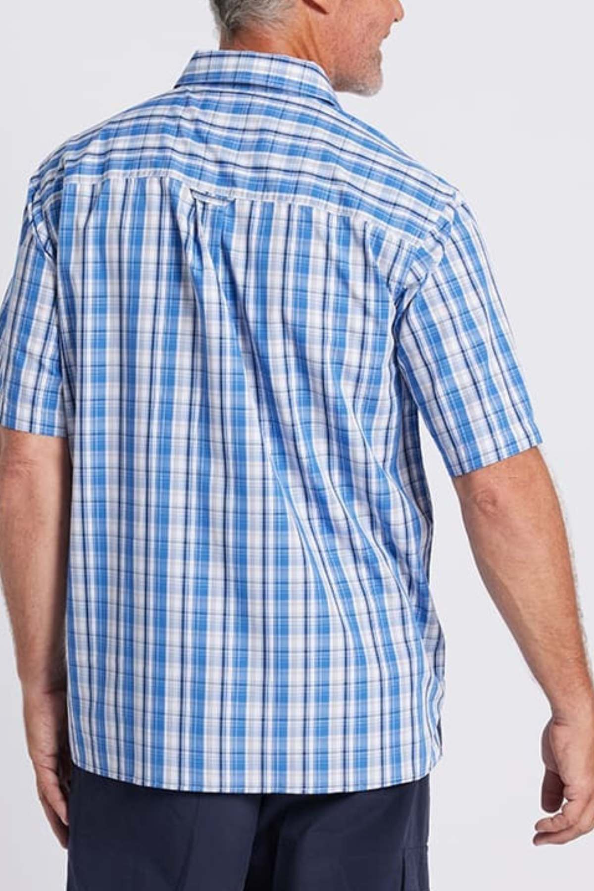 Seen from the back, a man with short gray hair wears the Breakaway Ora Bamboo Blend Shirt in serene seaside blue and white checkers. This button-down shirt boasts a relaxed fit that exudes effortless elegance, paired perfectly with dark pants.