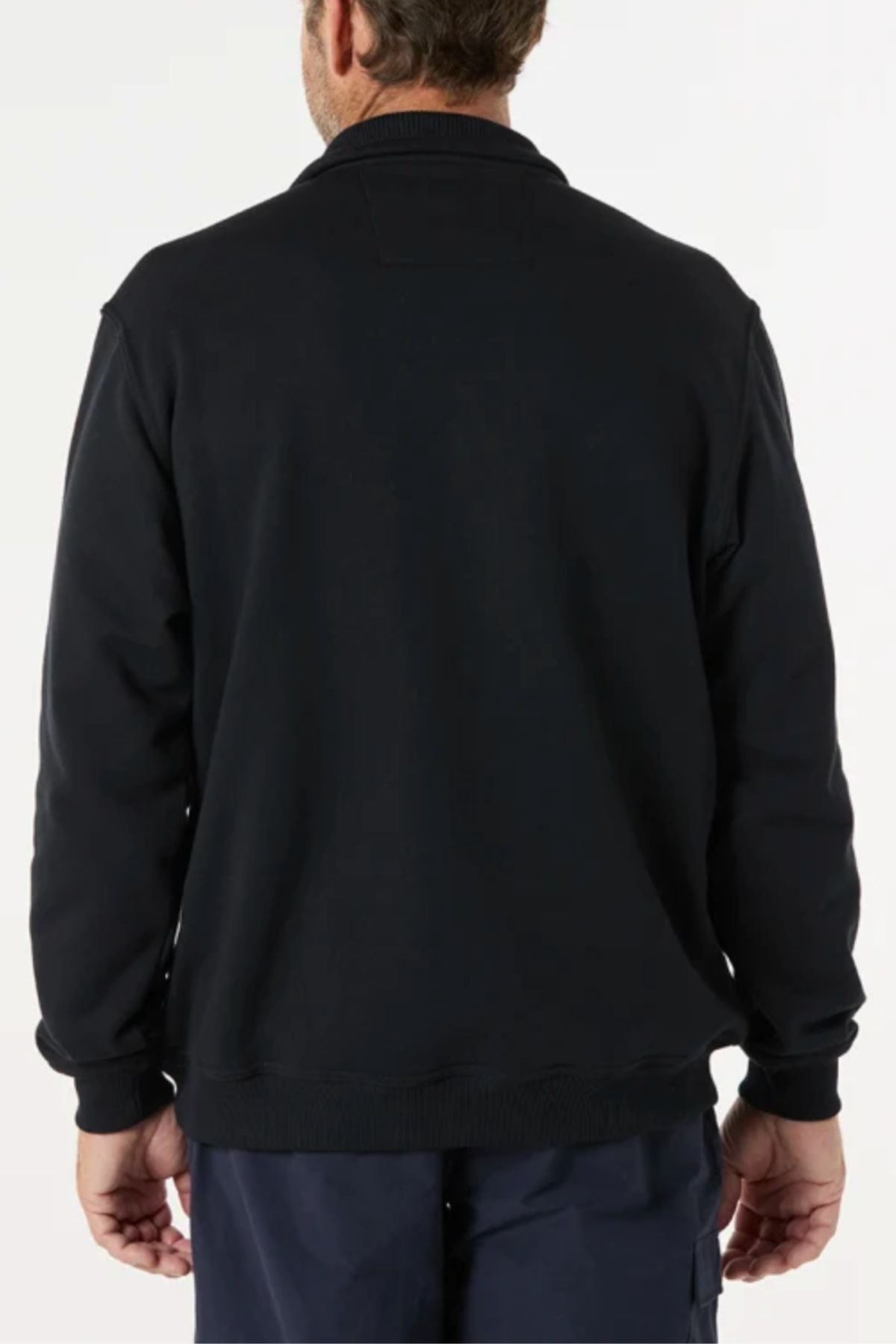 A man stands with his back to the camera, wearing a black Breakaway Zed Snowy Mt Fleece Half Zip pullover and dark pants against a plain light background.