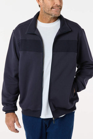 A man wears the Breakaway Zed Snowy Mt Fleece Jacket over a white tee and blue jeans, standing with one hand in his pocket and smiling slightly. The plain white background highlights this winter layering essential.