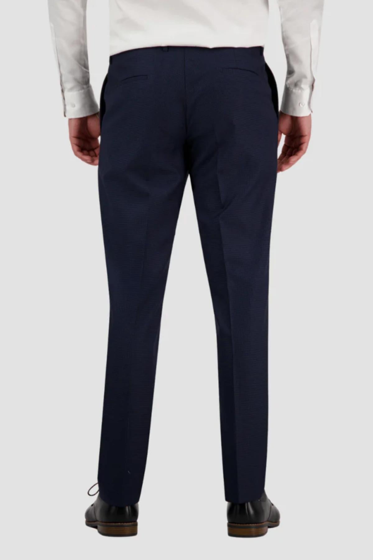 A person is seen from behind wearing a white dress shirt, dark blue Bruton Jesse Trouser, and black dress shoes.