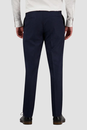 A person is seen from behind wearing a white dress shirt, dark blue Bruton Jesse Trouser, and black dress shoes.