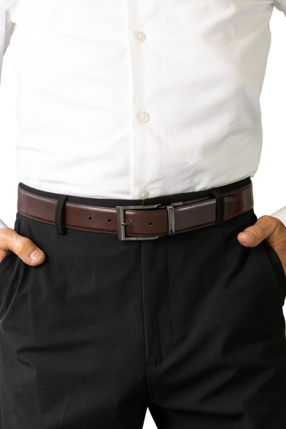 A person is wearing a white dress shirt tucked into black pants, styled with the Buckle 3508 Heritage 35mm Reversible Leather Belt, their hands resting in their pockets.