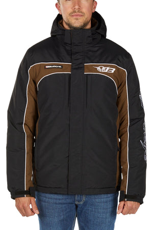 A man stands with his arms relaxed, wearing blue jeans and the Bullzye Bazooka Jacket—a black and brown waterproof, hooded jacket with white piping, logo details, and a front zipper for weather protection.