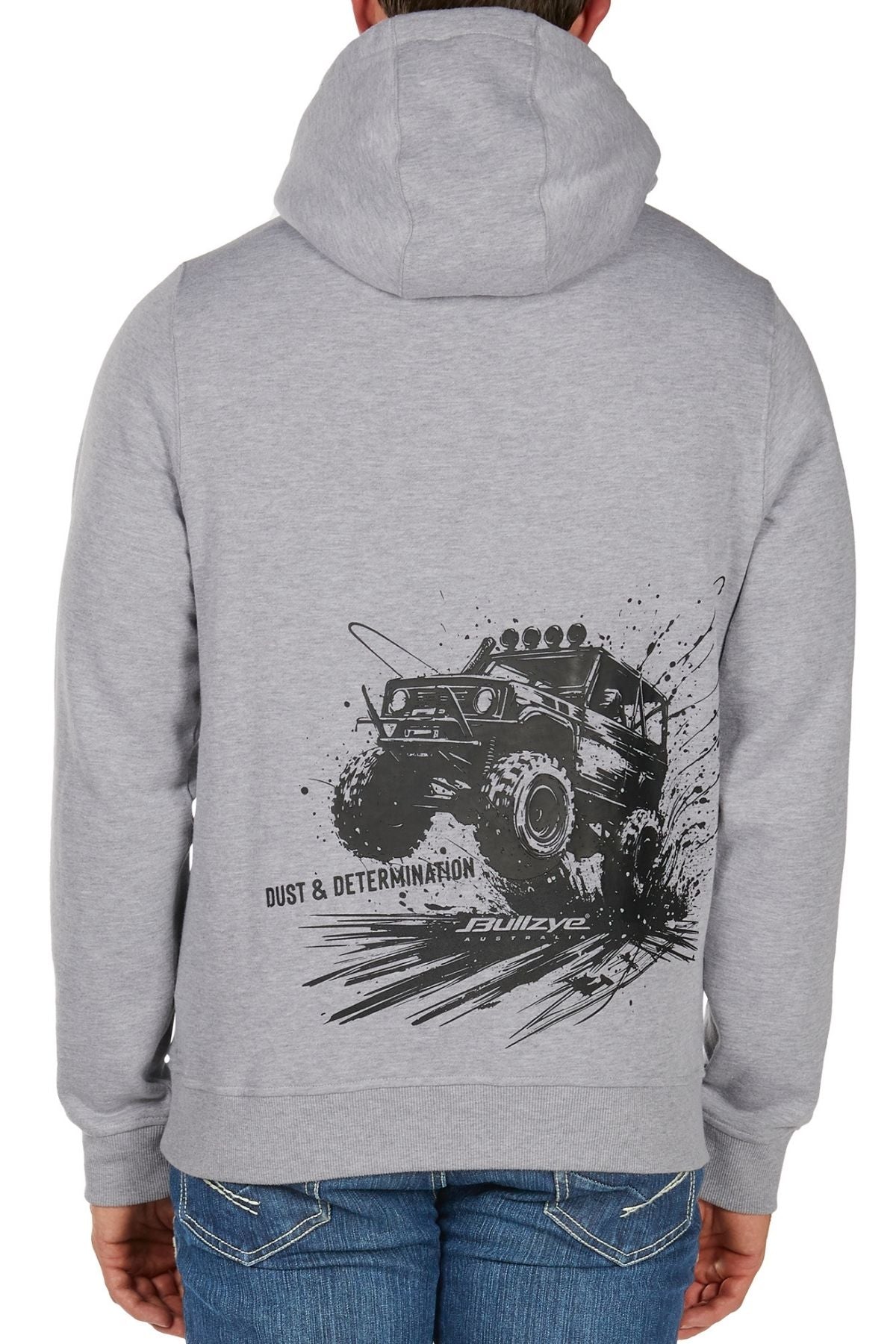 A person faces away from the camera, wearing the Bullzye Determination Hoodie. The back displays bold graphics of an off-road monster truck splashing mud and the phrase “DUST & DETERMINATION,” combining style with premium comfort.