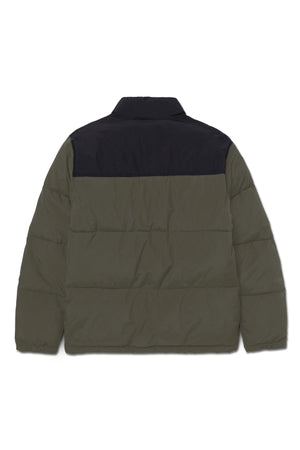 The CAT Heavy Weight Insulated Puffer Jacket features an olive green body and sleeves with a black upper back and collar. Shown flat with the back facing up, this water-resistant jacket keeps you warm in any weather.