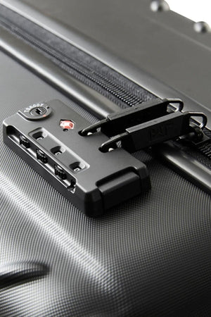 Close-up of the CAT Industrial Plate 20" Trolley, a black hard-shell carry-on with a textured, patterned finish and built-in TSA lock securing two zipper pulls.