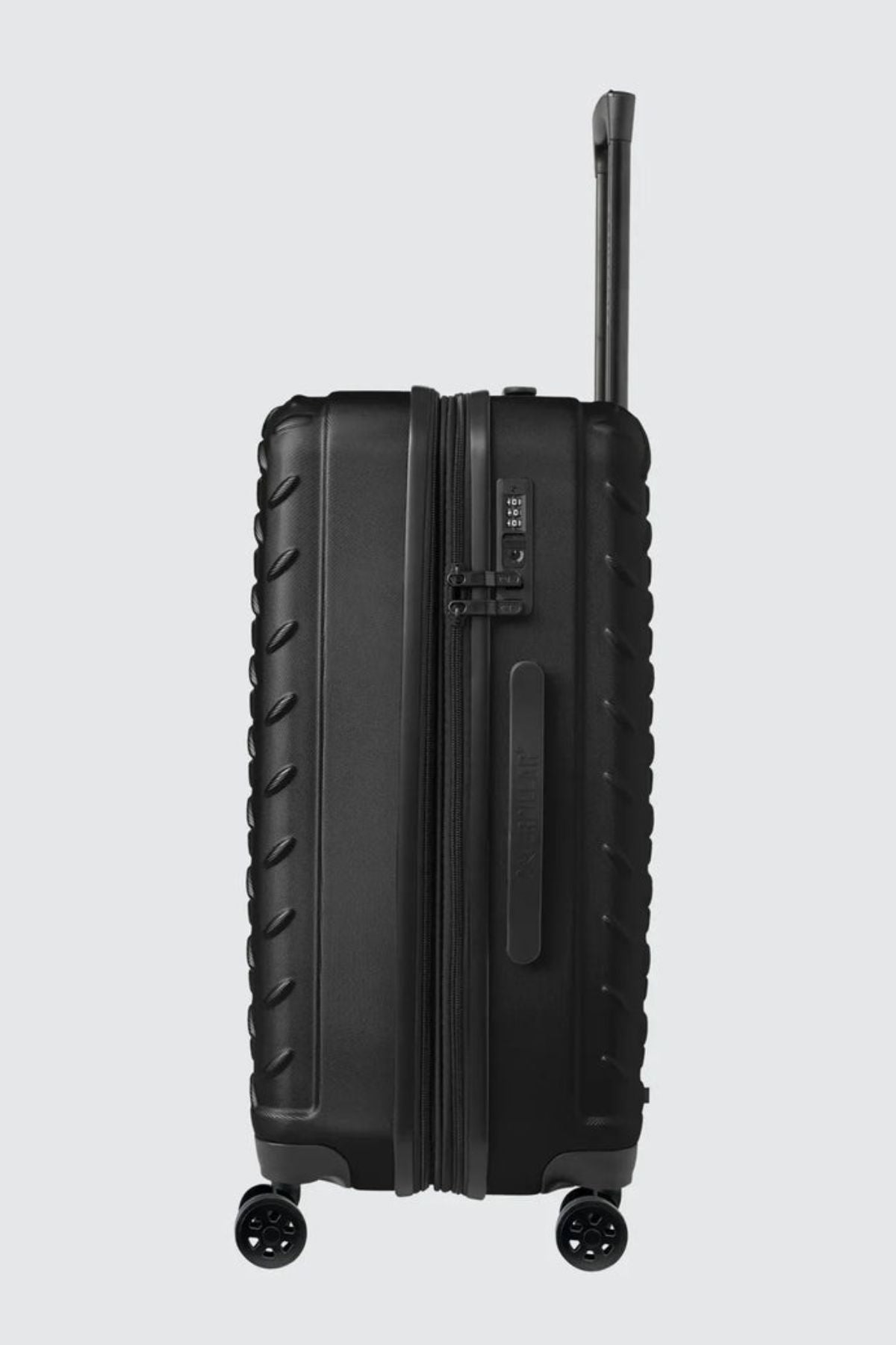 The CAT Industrial Plate 28" Trolley is a black hard-shell expandable suitcase with textured edges, four spinner wheels, a side handle, TSA lock, and an extended telescopic handle, shown upright against a light gray background.