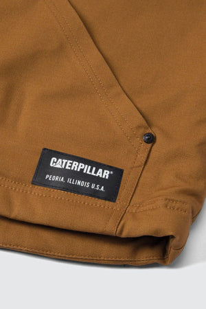 A close-up of the brown CAT Sherpa Lined Vest highlights a black label reading "Caterpillar®, Peoria, Illinois U.S.A." and a metal rivet near the seam.
