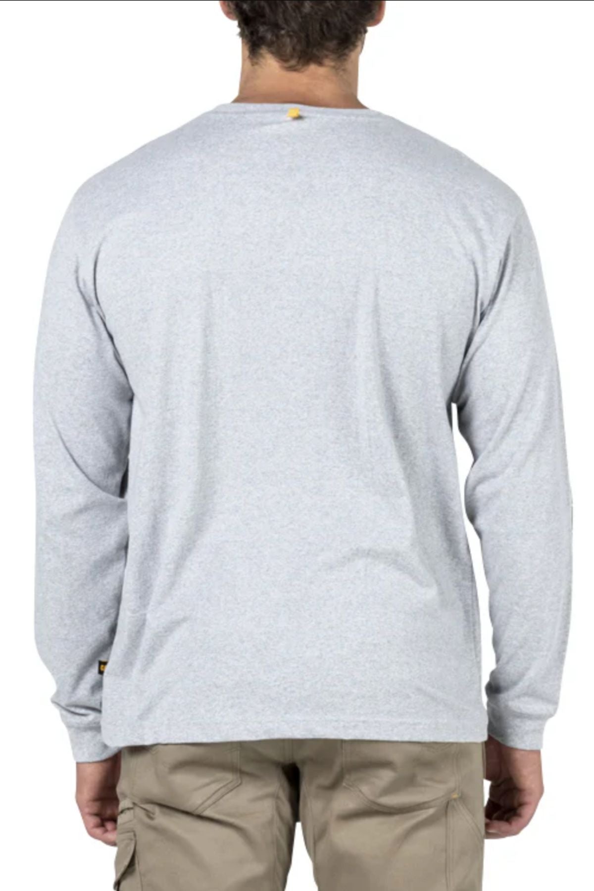 A person is seen from behind wearing a comfortable CAT Trademark Banner Long Sleeve Tee in light gray paired with beige cargo pants, standing against a plain white background.
