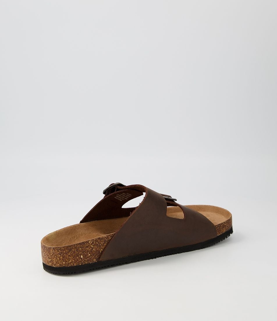 The Colorado Karra Crazyhorse Slide is a single brown leather sandal with a cork sole, black slip-resistant rubber outsole, and two wide buckle straps, shown against a plain light gray background.