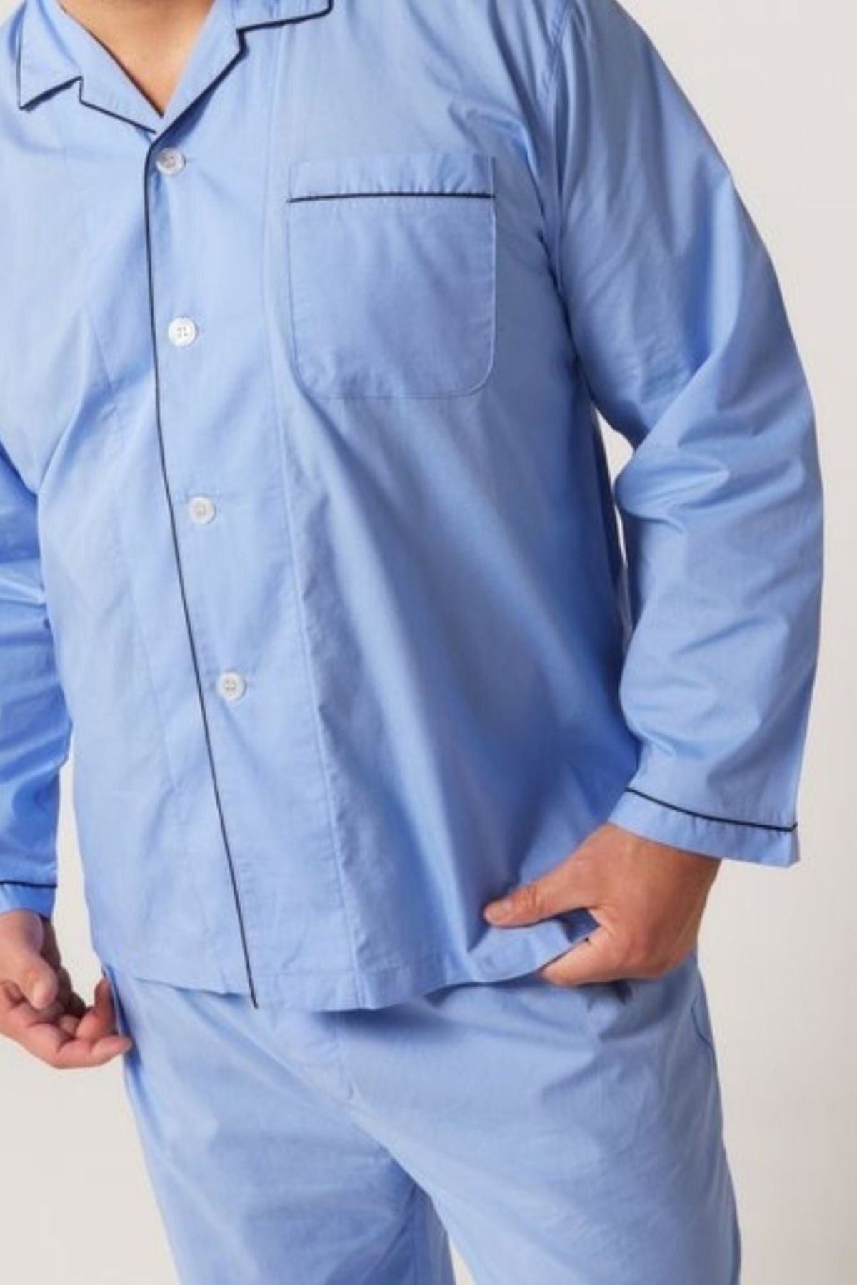 Model wears the Contare Country Cotton Rich Long Sleeve Classic Set in light blue with a chest pocket and dark trim, shown from shoulders to mid-thigh—ideal for comfortable sleepwear. One hand is at the side, the other near the hip.