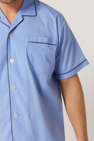 A person wears the Contare Country Cotton Rich Short Sleeve Classic Set in light blue, featuring black piping on the collar, pocket, and sleeves. Only the upper half is visible, highlighting this classic luxury sleepwear style.