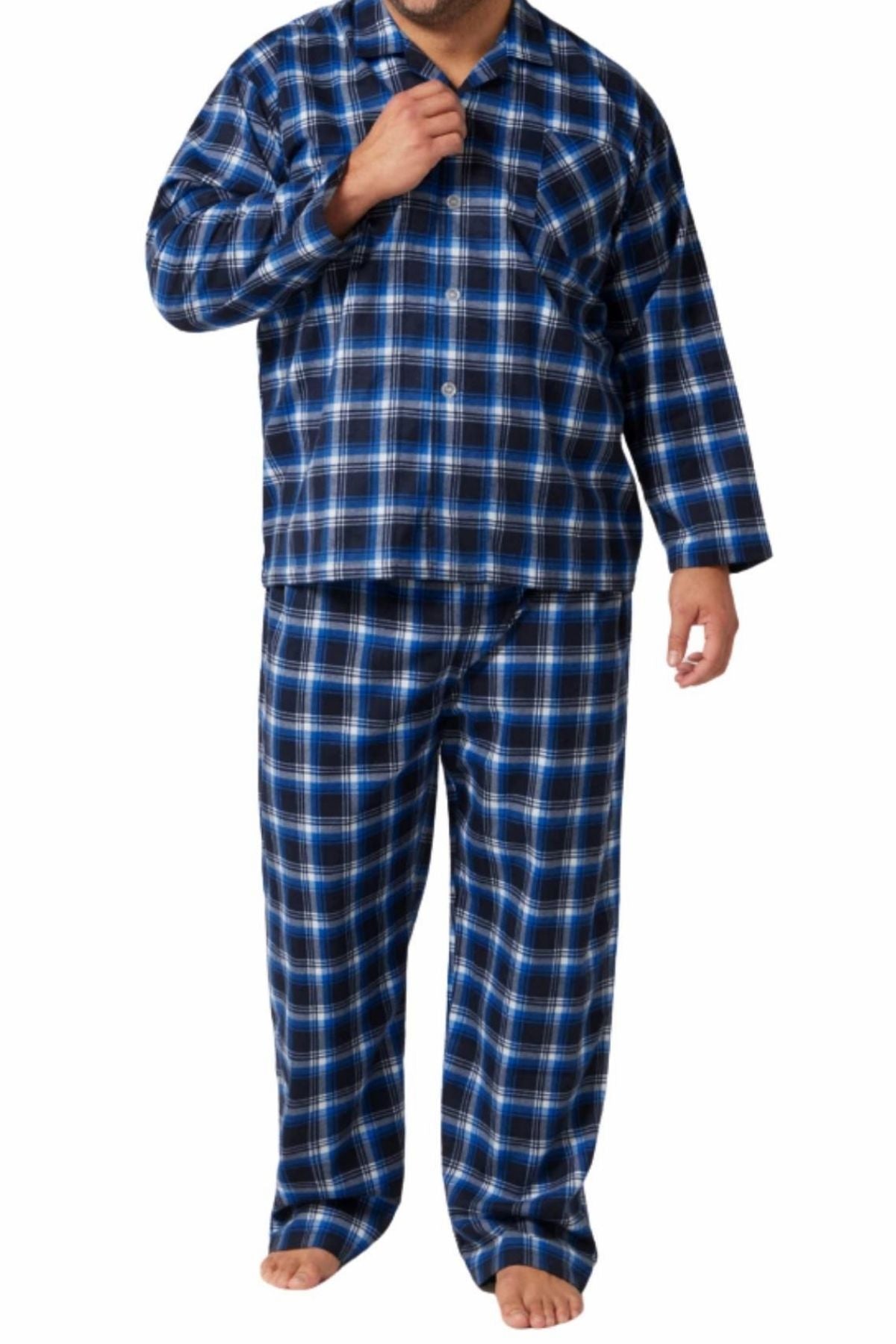 A man stands barefoot against a white background wearing the Contare Country Winter Flannelette PJ Set, a matching blue, black, and white plaid pajama set made from 100% cotton.