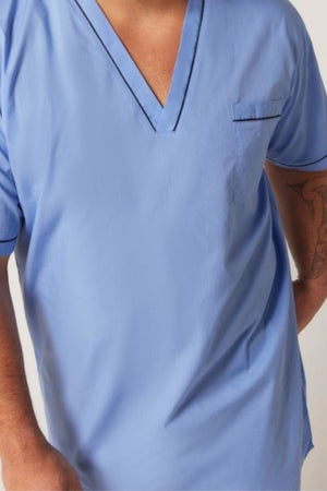 A person wearing the Contare Country Cotton Rich Short Sleeve Nightshirt in light blue with dark trim, V-neck, chest pocket, and short sleeves. Part of their right tattooed arm is visible; their face is not shown.
