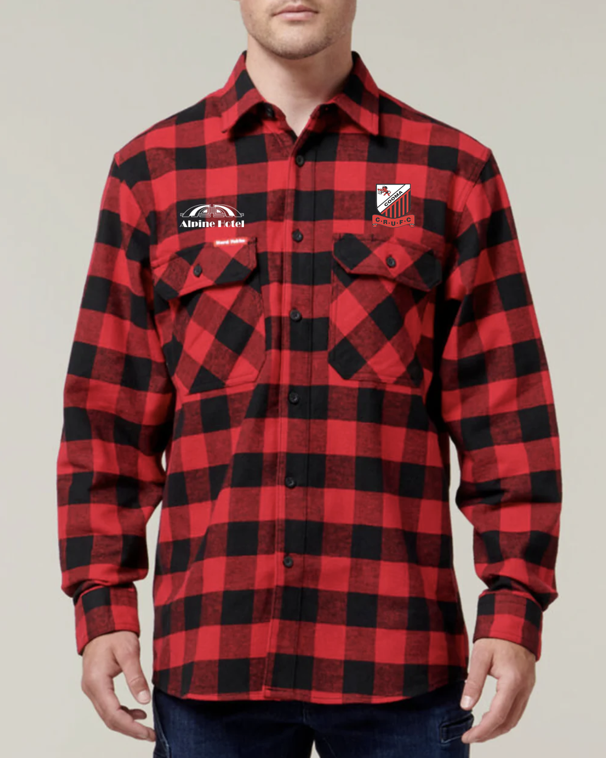 Sport the Cooma Rugby Red Devils Flannelette Shirt—red and black checkered with two chest logos: "Alpine Fuel" with a mountain graphic, and a red-and-white "CHIEFS" emblem. Ideal for Red Devils fans. Pre-order now!.