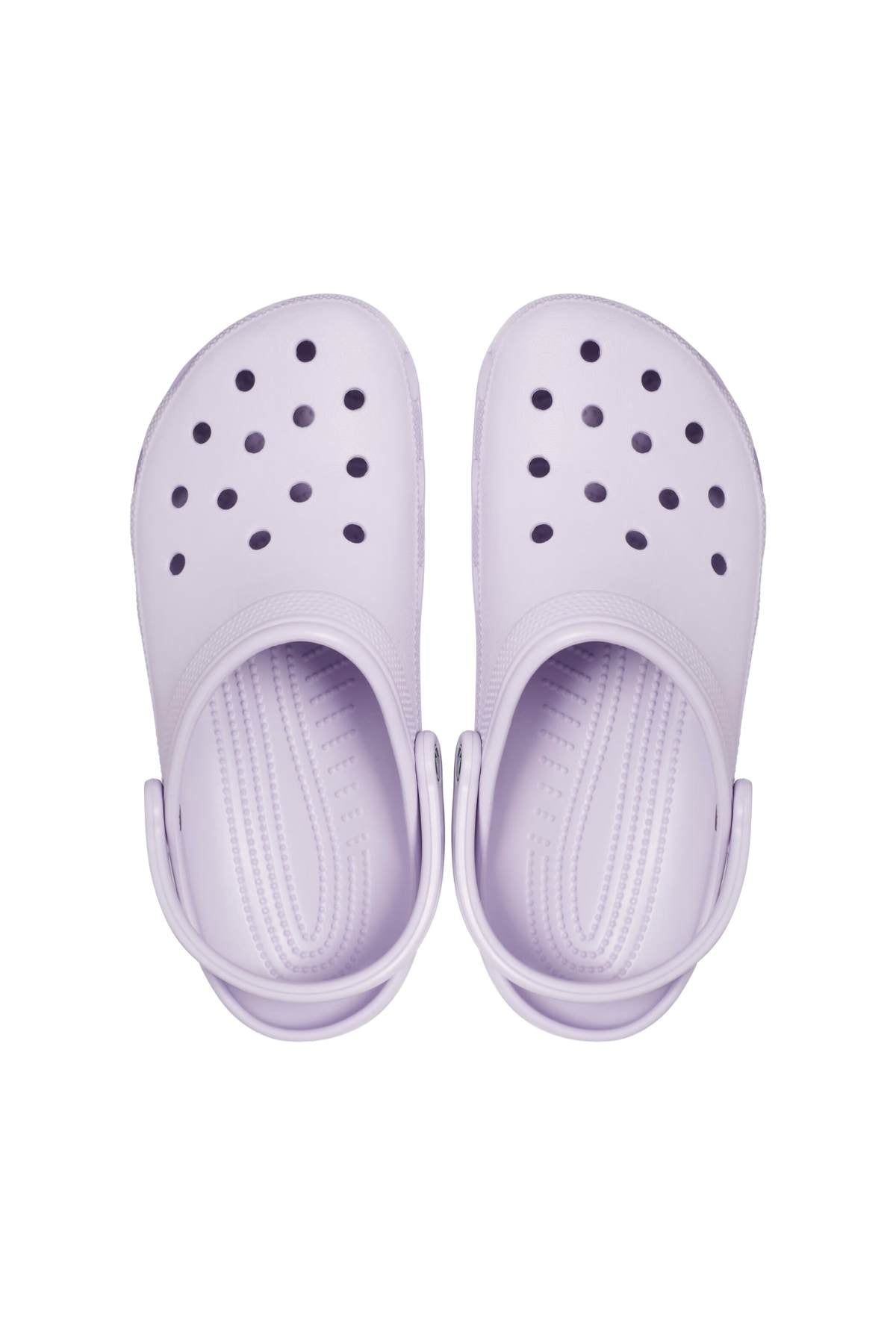 A pair of Crocs Classic Clog in light purple is shown from above, highlighting the breathable ventilation holes on the upper and forward-positioned heel straps. These lightweight shoes offer a textured insole for added comfort.