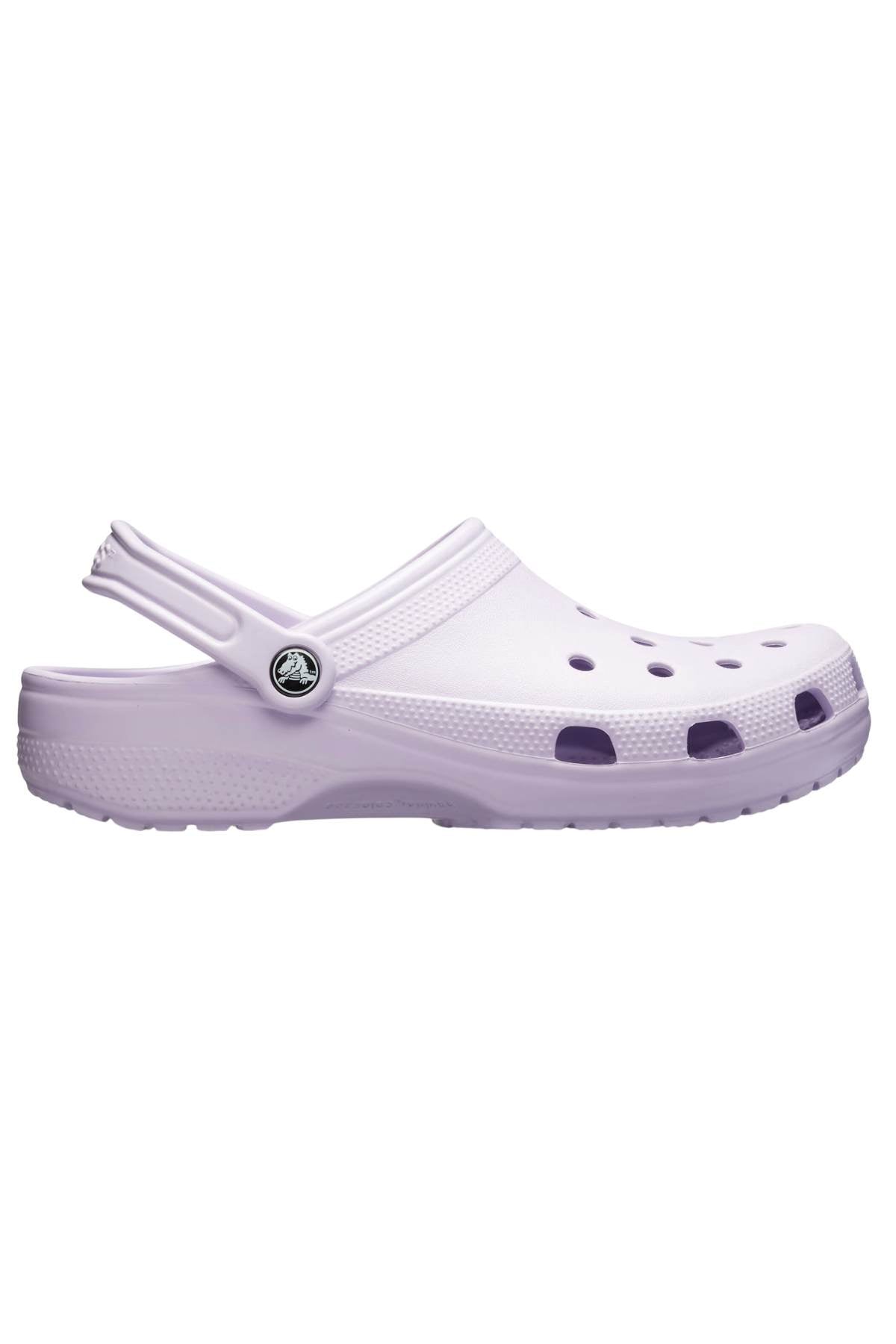 A side view of a single Crocs Classic Clog in lavender is shown, highlighting its lightweight design with a heel strap. It features circular and rectangular ventilation holes on the upper for enhanced breathability, complemented by a textured sole.