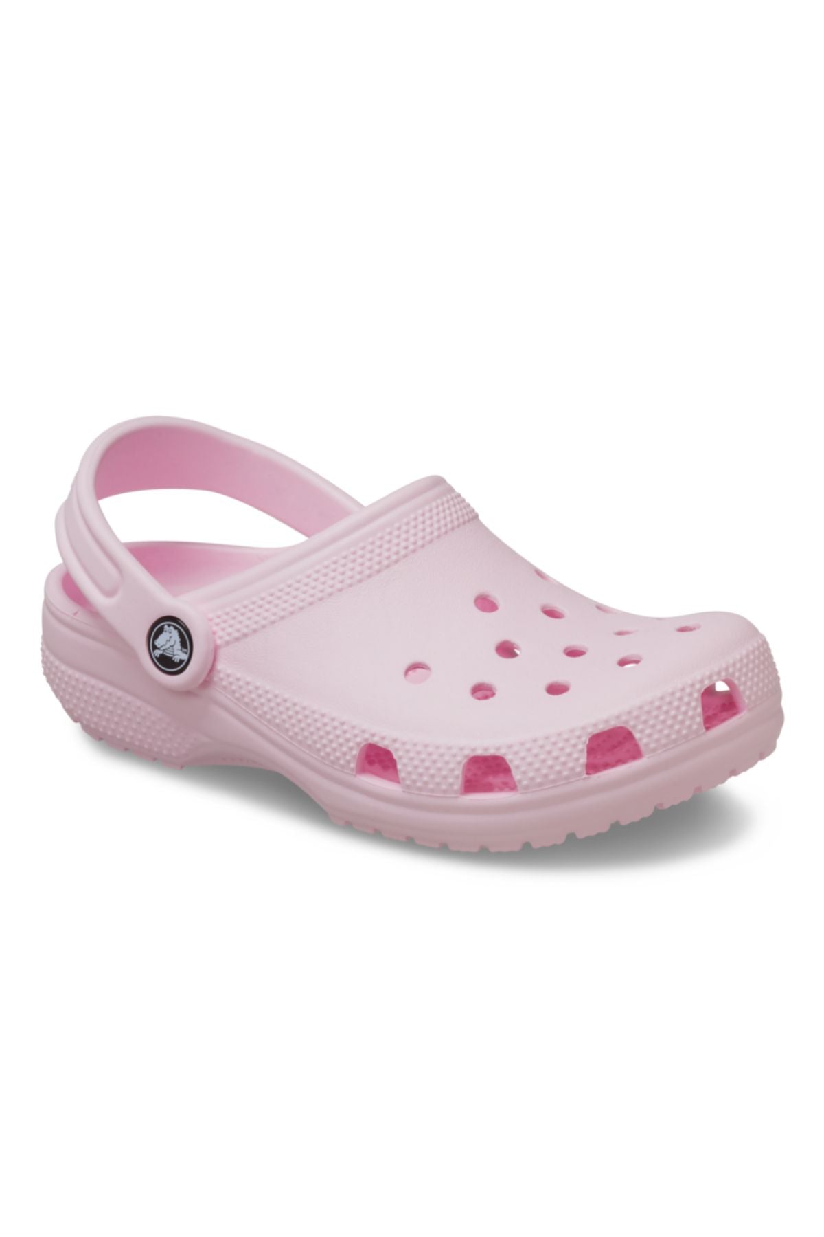 The Crocs Classic Kids Clog in light pink features ventilation holes, a textured sole, and a pivoting heel strap for comfort—ideal kids’ shoes—displayed on a plain white background.