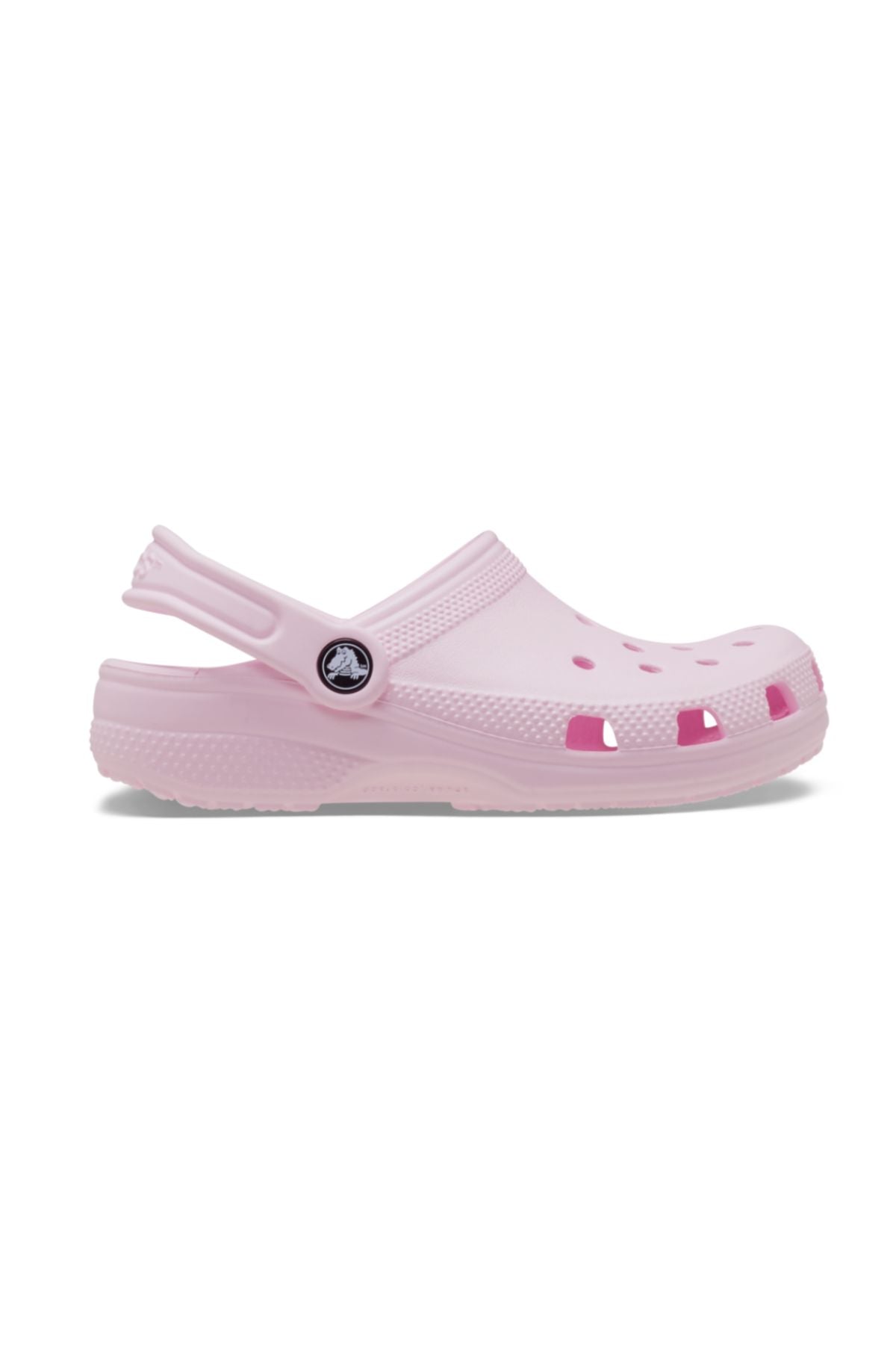 The Crocs Classic Kids Clog in light pink features top and side ventilation holes, a pivoting heel strap, and a textured sole—shown in side profile—making these comfortable shoes ideal for kids’ everyday wear.