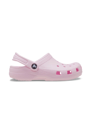 The Crocs Classic Kids Clog in light pink features top and side ventilation holes, a pivoting heel strap, and a textured sole—shown in side profile—making these comfortable shoes ideal for kids’ everyday wear.