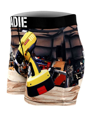 Tradie Mens Work N Surf Trunk: Workshop-themed boxer briefs with a large yellow power drill graphic, crafted from moisture-wicking, quick-drying fabric. The waistband is black with white text.