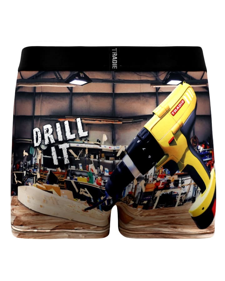 Moisture-wicking, quick-dry boxer shorts feature a workshop scene with a yellow power drill and wood workbench. "DRILL IT" is in white block letters; the waistband reads "TRADIE," ideal for the Tradie Mens Work N Surf Trunk collection.