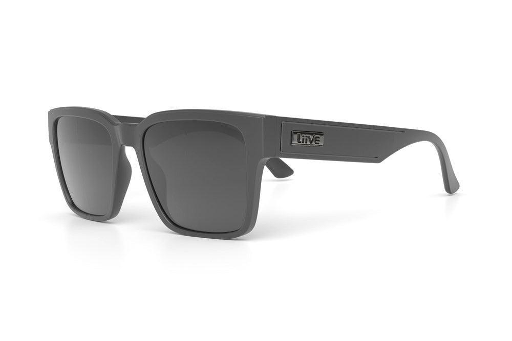 The Liive Danjo Polar Sunglasses are gray, rectangular, and polarized with dark lenses and thick frames. Featuring a "Liive" logo on the temple, these polycarbonate sunglasses are shown angled left on a white background.