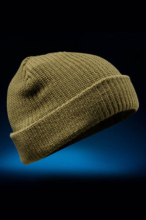 The FXD CP-10 Knit Ribbed Beanie, shown in khaki against a dark blue gradient background, features 100% acrylic fabric with a double knit layer and folded brim.
